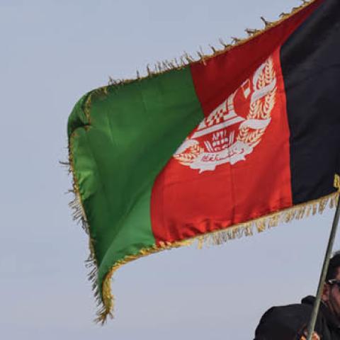 Afghan Commando beneath an Afghan national flag in Shindand Military Base, Herat province (Photo by Franz J. Marty/SOPA Images/LightRocket via Getty Images)