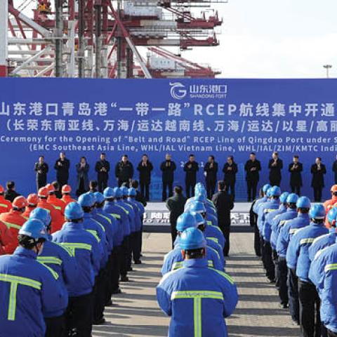 Workers attend the ceremony for the Opening of 'Belt and Road' RCEP Line, including EMC Southeast Asia Line, WHL/IAL Vietnam Line and WHL/IAL/ZIM/KMTC India Line, at Qingdao Port on January 19, 2021 in Qingdao, Shandong Province of China. (Photo by Zhang 