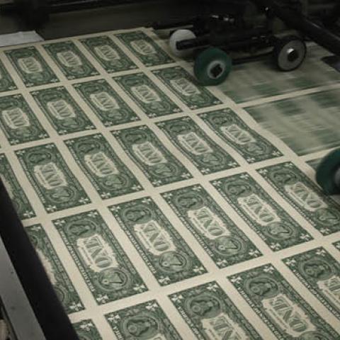 Sheets of one dollar bills run through the printing press at the Bureau of Engraving and Printing on March 24, 2015 in Washington, DC (Photo by Mark Wilson/Getty Images)