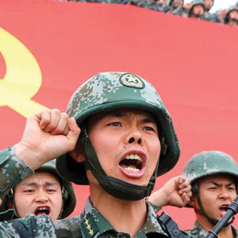 Members of the Communist Party of China (CPC) review the oath of joining the party in front of the party flag on April 13, 2021 in Luoyang, Henan Province of China. (Photo by Jia Fangwen/VCG via Getty Images)