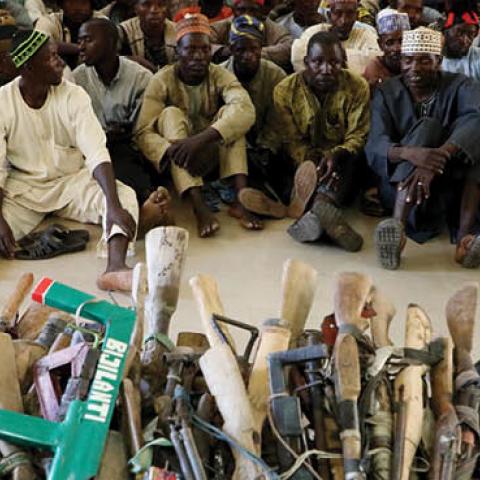 Members of the Yansakai vigilante group sit inside the Zamfara State Government house as their members surrendered more than 500 guns as part of efforts to accept the peace process of the state government (Photo by KOLA SULAIMON/AFP via Getty Images)