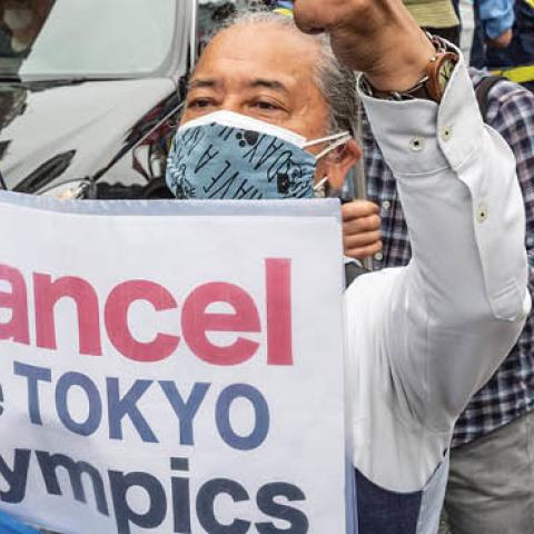 A protester holds a placard during a demonstration against the forthcoming Tokyo Olympic Games on June 06, 2021 in Tokyo, Japan (Photo by Yuichi Yamazaki/Getty Images)