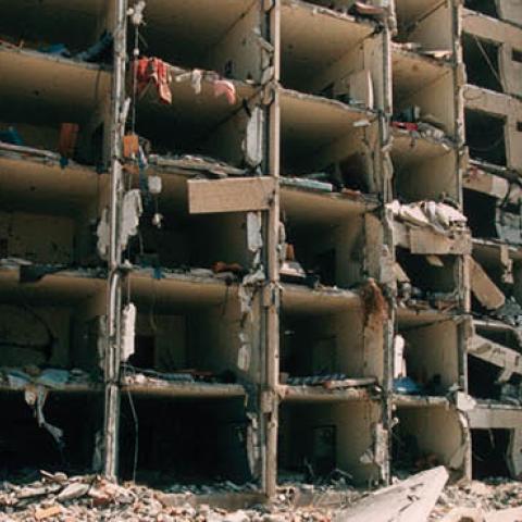 Debris lies on the ground by the wreckage of Khobar Towers in Dhahran, Saudi Arabia June 29, 1996 after a truck bomb exploded four days previously, killing 19 American servicemen residing there (Photo by Scott Peterson/Getty Images)