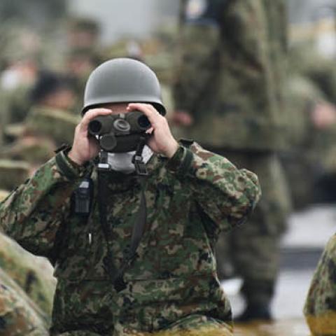 A Japan's Ground Self-Defense Forces (JGSDF) soldier uses binoculars during a live fire exercise at JGSDF's training grounds in the East Fuji Maneuver Area on May 22, 2021 in Gotemba, Shizuoka, Japan (Photo by Akio Kon - Pool/Getty Images)