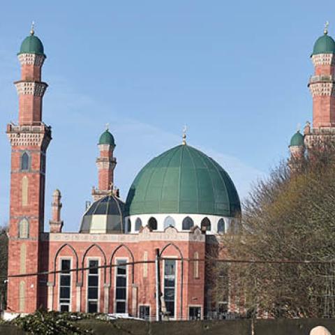 A lady walks past Al-Jamia Suffa-Tul-Islam Grand Mosque on February 12, 2021 in Bradford, England. (Photo by Nathan Stirk/Getty Images)