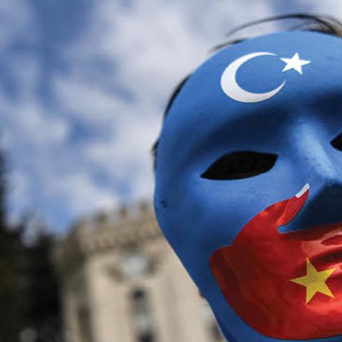 A demonstrator wearing a mask painted with the colors of the flag of East Turkestan takes part in a protest by supporters of the Uighur minority on April 1, 2021 at beyazid square in Istanbul (Photo by OZAN KOSE/AFP via Getty Images)