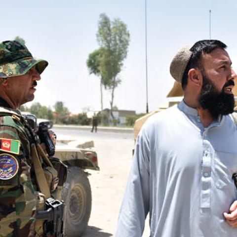 Afghan security personnel stand guard along the road amid ongoing fight between Afghan security forces and Taliban fighters in Kandahar on July 9, 2021 (Photo by JAVED TANVEER/AFP via Getty Images)