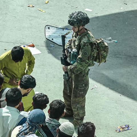 US soldiers stand guard as Afghan people wait at the Kabul airport in Kabul on August 16, 2021 (Photo by WAKIL KOHSAR/AFP via Getty Images)