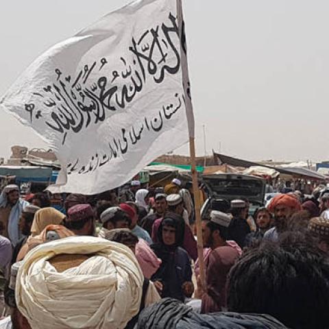 People gather around a Taliban flag as they wait for relatives released from jail in Afghanistan following an 'amnesty' by the Taliban, near the Pakistan-Afghanistan border crossing point in Chaman on August 17, 2021 (AFP via Getty Images)