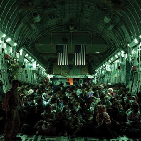 An air crew assists evacuees aboard a C-17 Globemaster III aircraft in support of the Afghanistan evacuation at Hamid Karzai International Airport on August 21, 2021 in Kabul, Afghanistan. (Taylor Crul/U.S. Air Force via Getty Images)