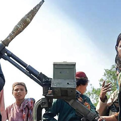 Taliban fighters sit over a vehicle on a street in Laghman province on August 15, 2021 (AFP via Getty Images)