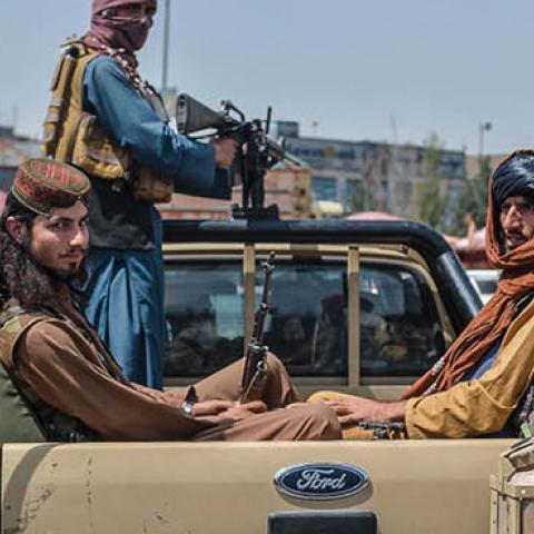 Taliban fighters on a pick-up truck move around a market area, flocked with local Afghan people at the Kote Sangi area of Kabul on August 17, 2021, after Taliban seized control of the capital following the collapse of the Afghan government (Photo by HOSHA