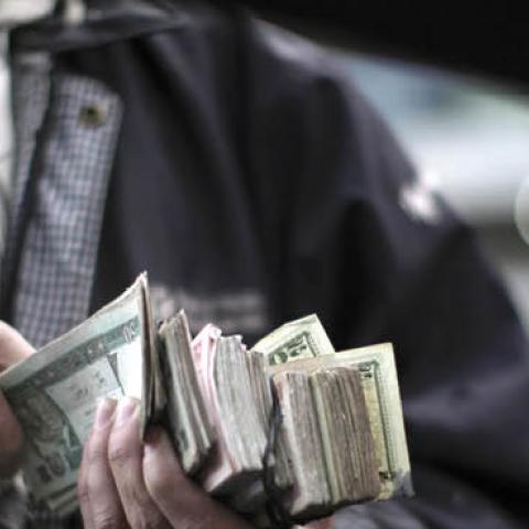 An Afghan street seller offers the local currency called 'afgani' in exchange for US dollars and few pre-paid mobile phone cards, in Kabul, on April 10, 2010. (MAURICIO LIMA/AFP VIA GETTY IMAGES)