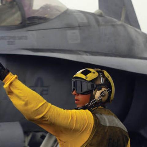 A plane director signals to the pilot of an F/A-18C Hornet from the "Wildcats" of Strike Fighter Squadron (VFA) 131 after landing on the flight deck of the Nimitz-class aircraft carrier USS Dwight D. Eisenhower (U.S. Navy)