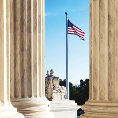 An American flag seen through columns at the United States Supreme Court. (Justin Tierney via Getty Images)