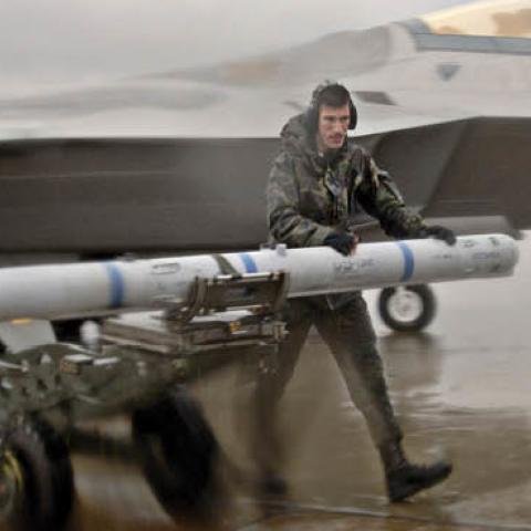 U.S. servicemen walk through rain and strong winds with an AIM-120 missile on January 31, 2006. (U.S Air Force photo by Staff Sgt. Eric T. Sheler)