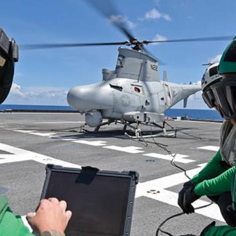 Aviation machinists perform maintenance on a MQ-8B unmanned helicopter on the flight deck of the Independence-variant littoral combat ship USS Gabrielle Giffords (LCS 10), May 14, 2020. (U.S. Navy)