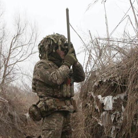 A Ukrainian Military Forces serviceman watches through spyglass in a trench on the frontline with Russia-backed separatists near to Avdiivka, southeastern Ukraine, on January 9, 2022. (Photo by ANATOLII STEPANOV/AFP via Getty Images)