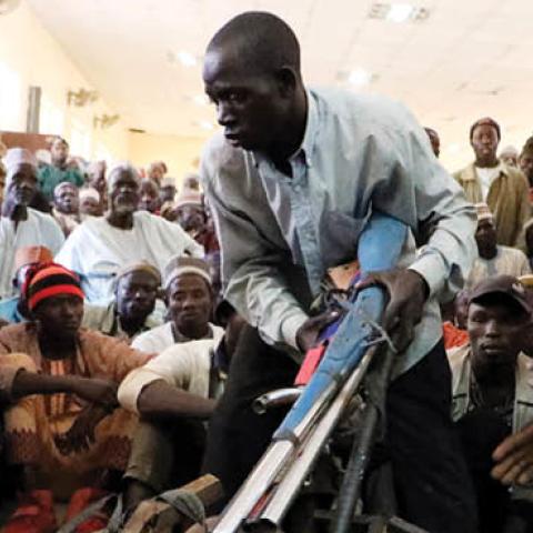 Members of the Yansakai vigilante group lay their weapons on the floor in Gusau, on December 3, 2019. (Photo by Kola Sulaimon / AFP via Getty Images)