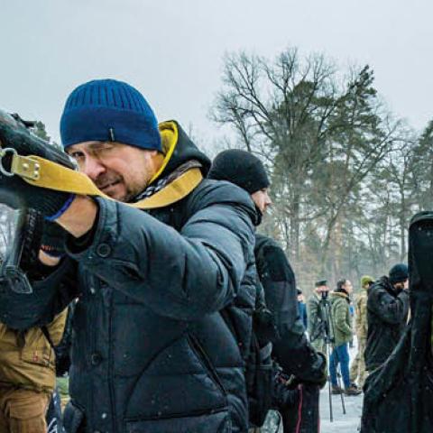 Civilian volunteer of the 112th Territorial Defense Brigade of Kiev points with his rifle during a military training for civilians in the outskirts of the city. (Photo by Celestino Arce/NurPhoto via Getty Images)