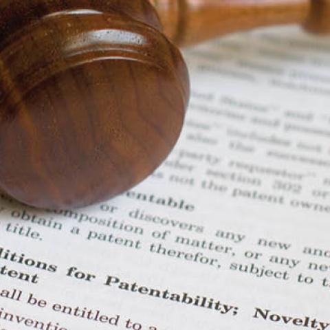 A gavel resting on the legal code outlining conditions for patentability. (csreed via Getty Images)