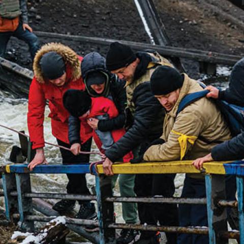 Soldiers help civilians cross a broken bridge as they flee their besieged city of Irpin, Ukraine, Tuesday, March 1, 2022. (Marcus Yam/Los Angeles Times/Getty Images) 