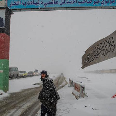 A man looks on at a snow-covered security checkpoint that marks the entrance to Logar province, beyond the southern gate on January 17, 2022 in Kabul, Afghanistan. (Photo by Scott Peterson/Getty Images)