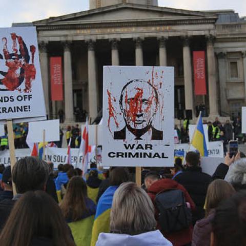 Protesters hold signs accusing Putin of war crimes as demonstrators gather in Trafalgar Square calling for unity against Russia on March 20, 2022 in London, England. (Photo by Martin Pope/Getty Images)