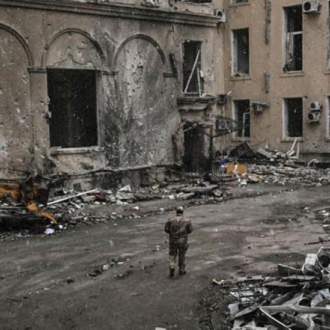 A Ukranian serviceman walks between rubble of the destroyed regional headquarters of Kharkiv on March 27, 2022. (Photo by Aris Messinis / AFP via Getty Images) 