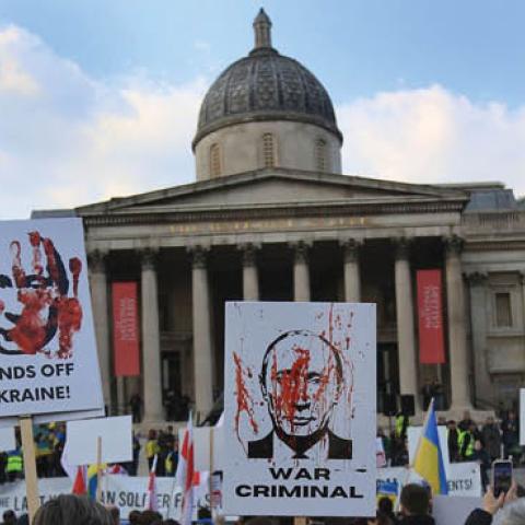 Protesters hold signs accusing Putin of war crimes as demonstrators gather in Trafalgar Square calling for unity against Russia on March 20, 2022 in London, England. (Photo by Martin Pope/Getty Images)
