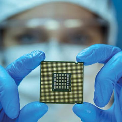 Engineer analyzes a computer chip in a lab. (D-Keine/Getty Images)