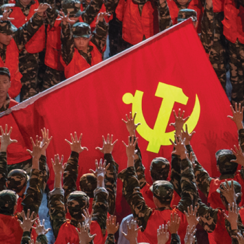 During a gala marking the 100th anniversary of the Communist Party, performers dressed as emergency workers surround a large Communist Party flag on June 28, 2021 at the Olympic Bird's Nest stadium in Beijing, China. (Photo by Kevin Frayer/Getty)