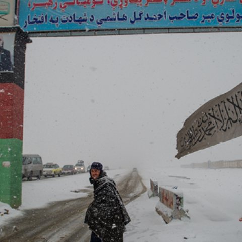A man looks on at a snow-covered security checkpoint that marks the entrance to Logar province, beyond the southern gate on January 17, 2022, in Kabul, Afghanistan. (Scott Peterson/Getty Images)