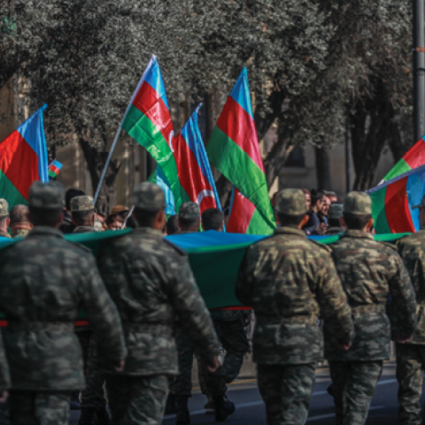Azeri service members carry a giant flag during a procession marking the anniversary of the end of the 2020 military conflict over Nagorno-Karabakh breakaway region on November 8, 2021, in Baku, Azerbaijan. (Aziz Karimov/Getty Images)