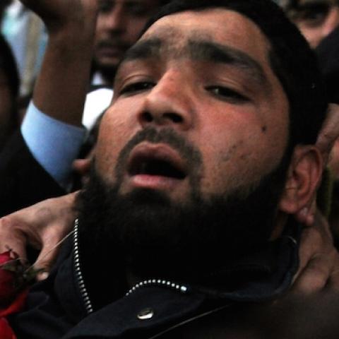 Arrested Pakistani bodyguard Malik Mumtaz Hussain Qadri wearing a garland leaves the court in Islamabad on January 5, 2011 a day after the assassination of the governor of Punjab province Salman Taseer. (AAMIR QURESHI/AFP/Getty Images)
