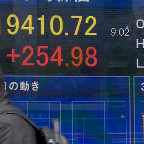 A pedestrian walks past a stock indicator board showing the share price of the Tokyo Stock Exchange in Tokyo on December 26, 2018. (KAZUHIRO NOGI/AFP/Getty Images)