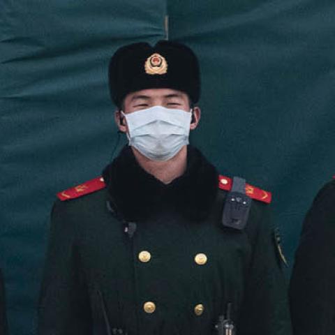 Chinese police wear protective masks as they stand guard on a main road on January 31, 2020 in Beijing, China (Photo by Kevin Frayer/Getty Images)